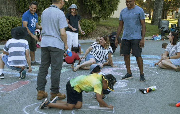 Children and parents drawing on a pavement