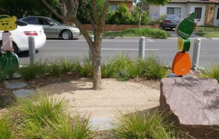a tree on the nature strip of a street