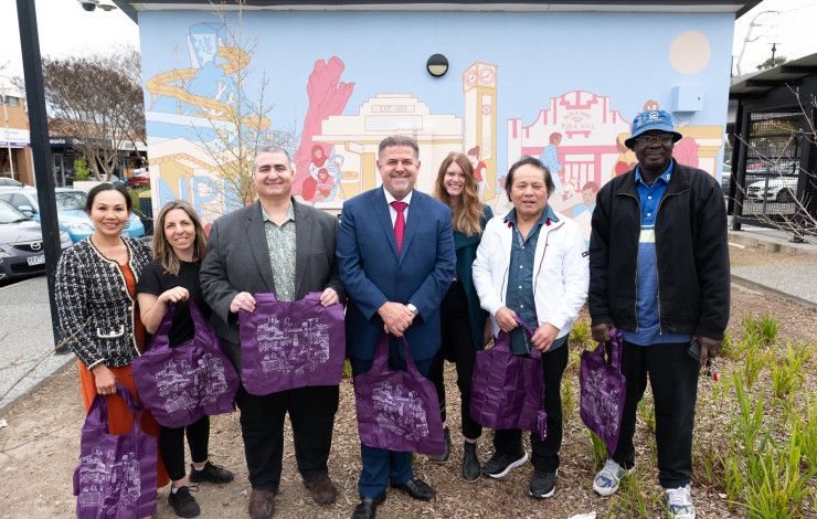 People standing in front of Noble Park mural
