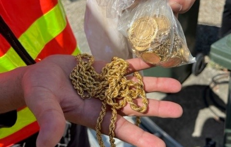 a person holding a gold necklace 