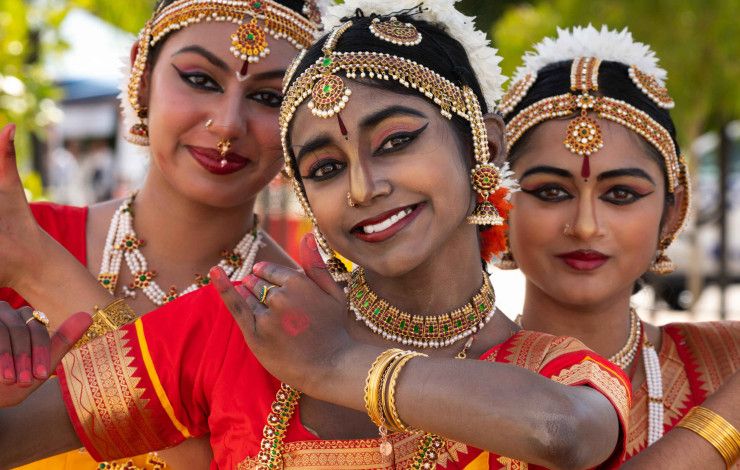 Three Kuchipudi dancers in bright-coloured traditional dress