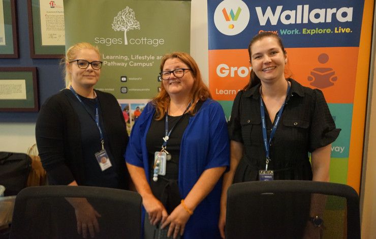 Three people standing in front of some banners.