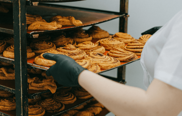 A baker loading pastries on to a rack.