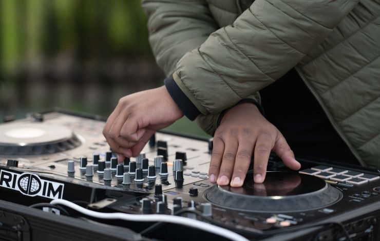 Hands working a turntable music mixing desk