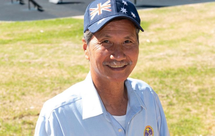 Smiling Vietnamese man wearing a hat featuring the Australian flag.