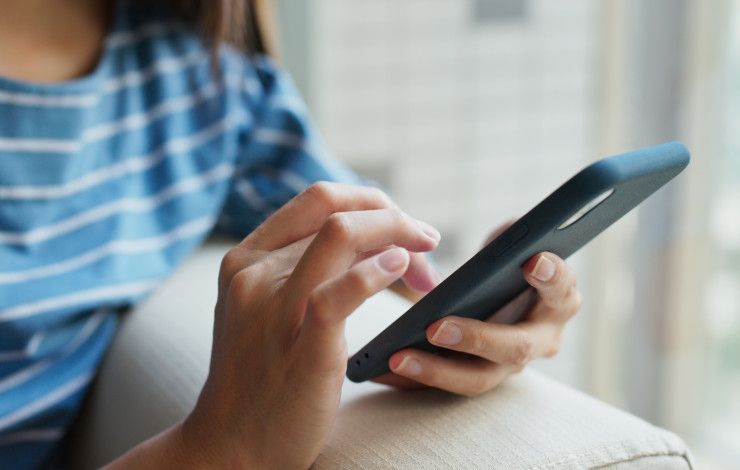 Closeup of a person's hands using a mobile phone.