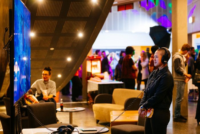 Person in a theatre foyer watching something on a screen