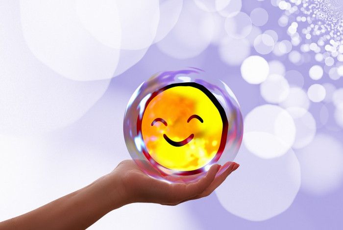 A hand holding a smiley face