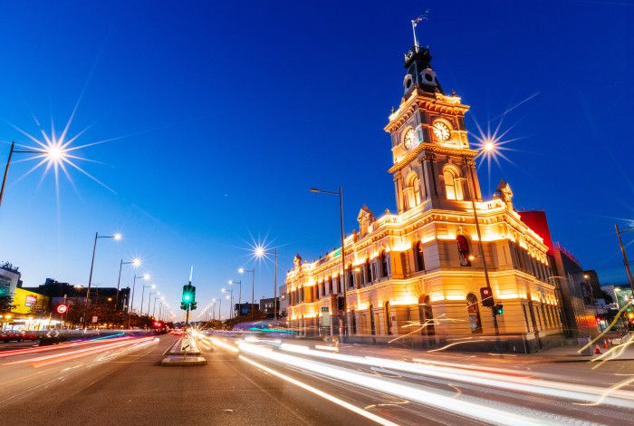 Large historical building lit up at dusk.
