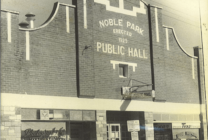 An ornate brick building with a sign reading Noble Park Public Hall erected 1825.