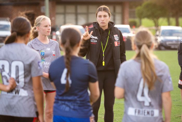 Coach and players on a sporting ground