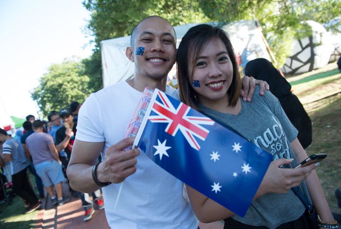 Two smiling people holding an Australian Flag