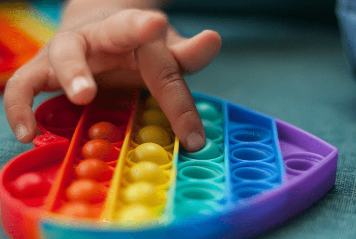 Heart shaped rainbow coloured sensory toy.