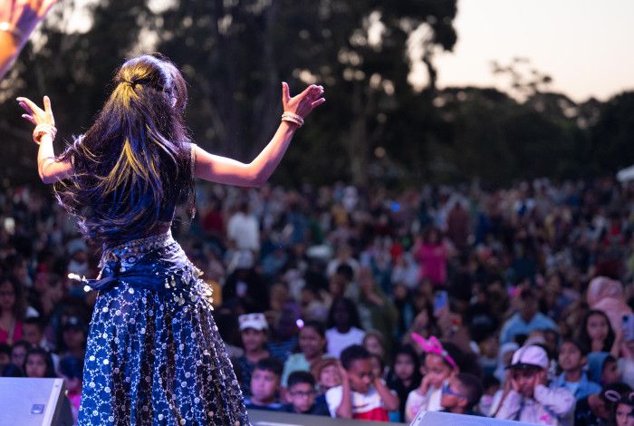A woman dances on stage in front of a large crowd