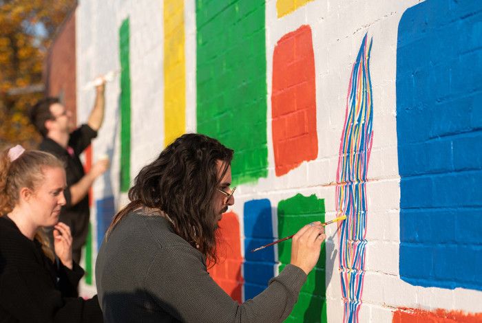 People painting a mural on a wall