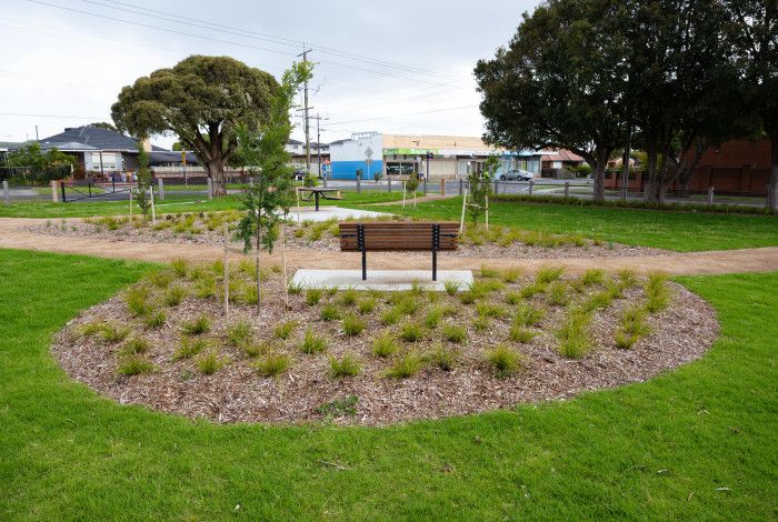 Overlooking a park bench in the middle of a grassy park