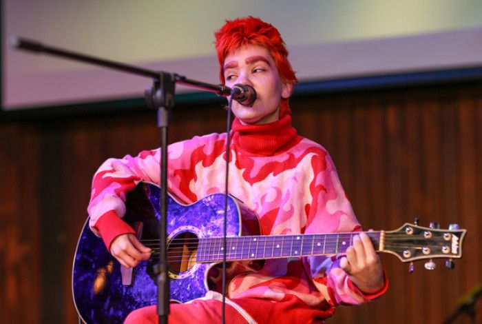 Young person playing guitar and singing
