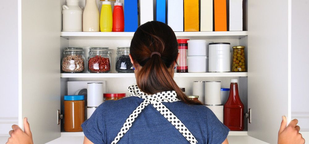 Woman looking into pantry cupboard