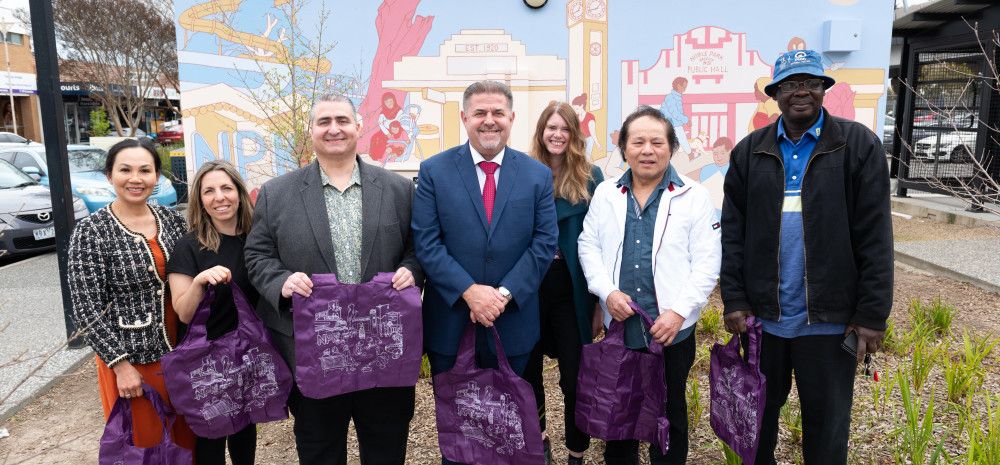 People standing in front of Noble Park mural
