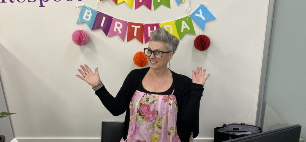 person in front of words happy birthday