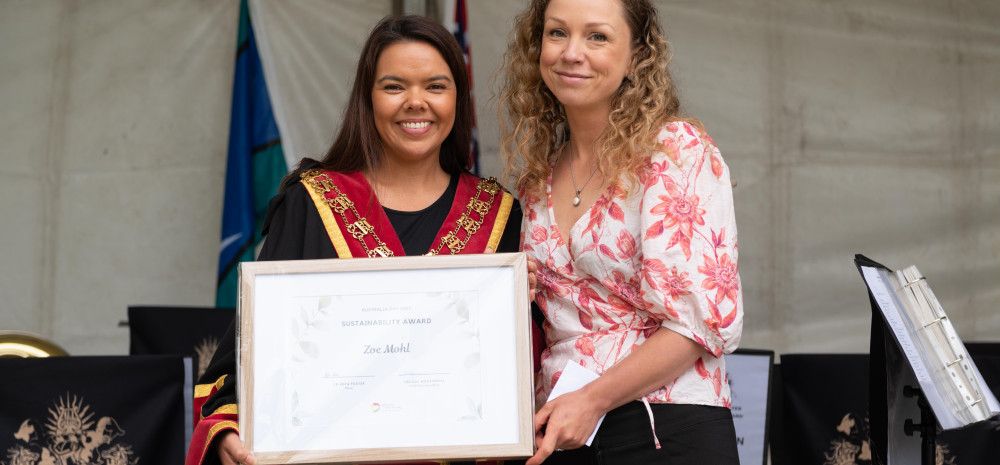 Mayor Eden Foster and Zoe Mohl holding a framed certificate