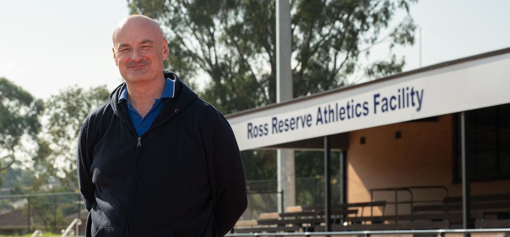 Councillor Sean O'Reilly standing in front of the Ross Reserve Athletics track