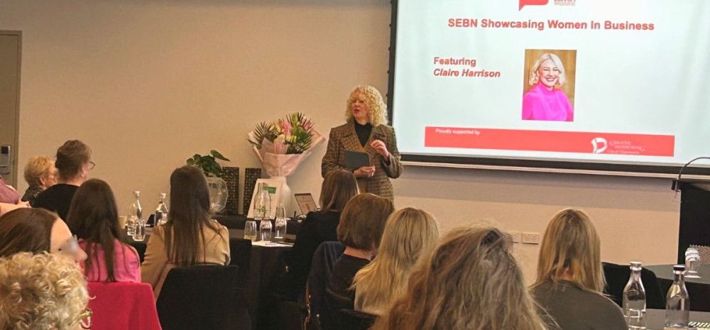 Claire Harrison standing infront of people seated at tables