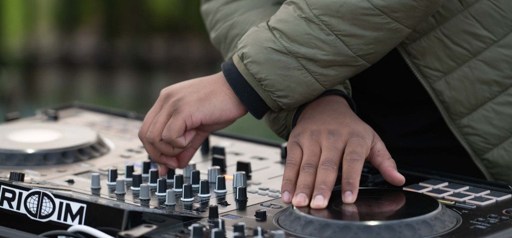 Hands working a turntable music mixing desk