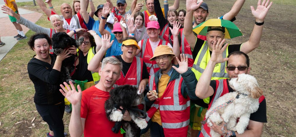 Group of Parkrun Volunteers smiling with their arms up