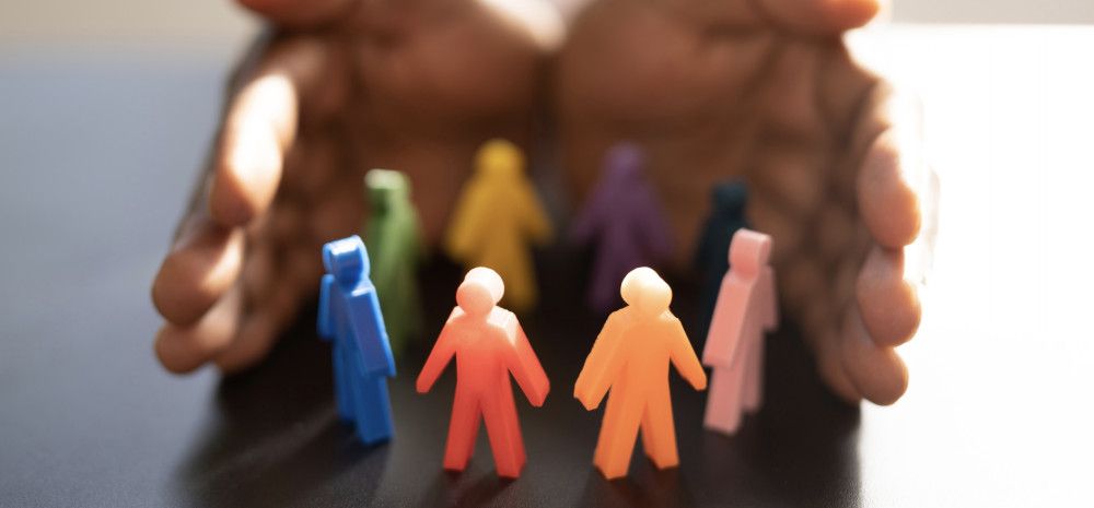 Colorful figures of humans being cupped by two hands.