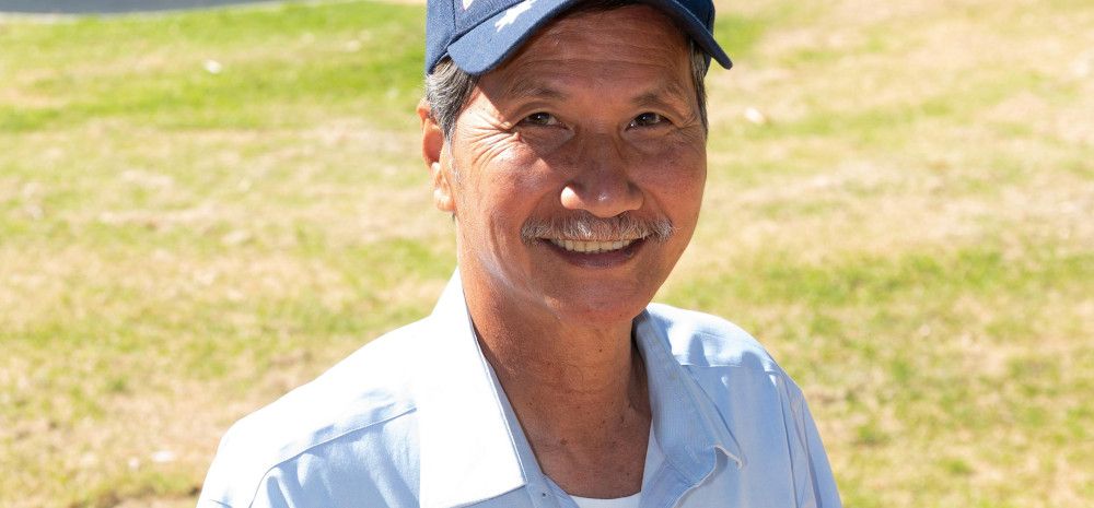 Smiling Vietnamese man wearing a hat featuring the Australian flag.