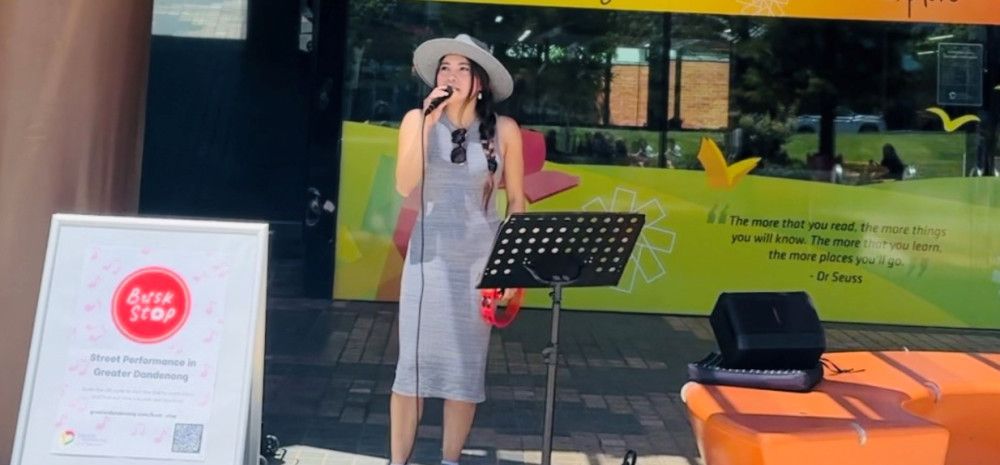 A person busking outside Dandenong Library.