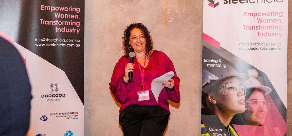 A lady talking holding a microphone and paper