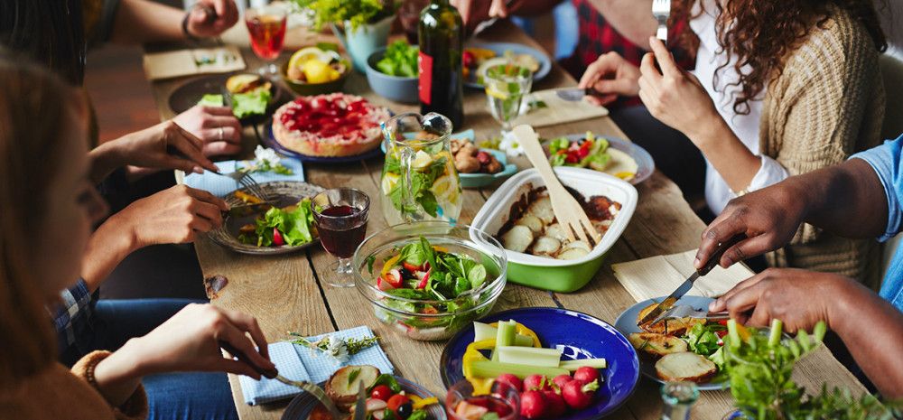 Food on a dinning table with people eating