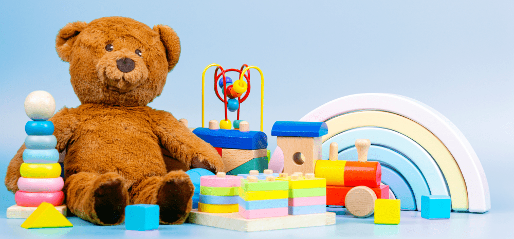 Teddy bear and various toys against a light blue background