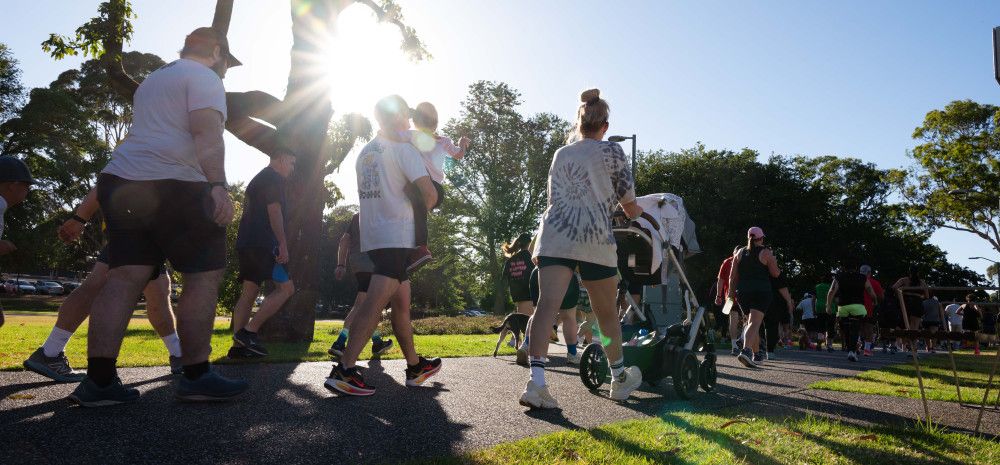 The backs of people walking in a park