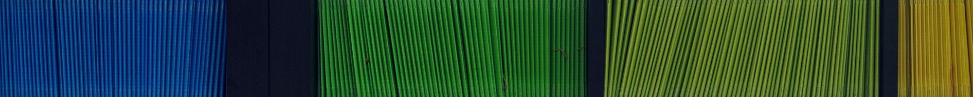 Coloured folders stacked on a book case