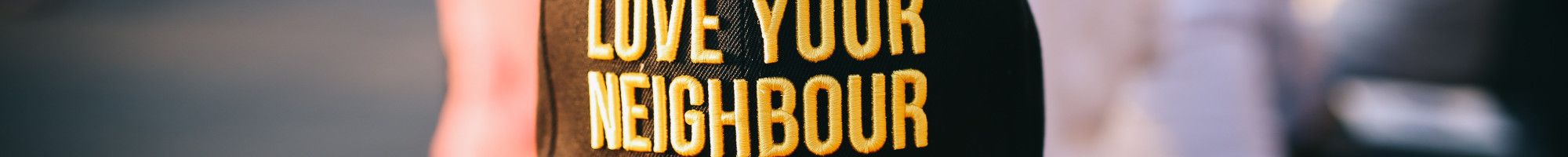 Man wearing Love Your Neighbor cap