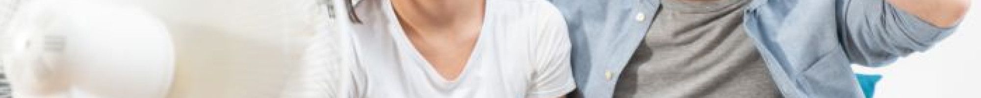 two people sitting in front of a fan