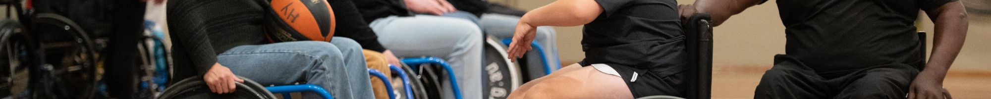 People on a basketball court in wheelchairs