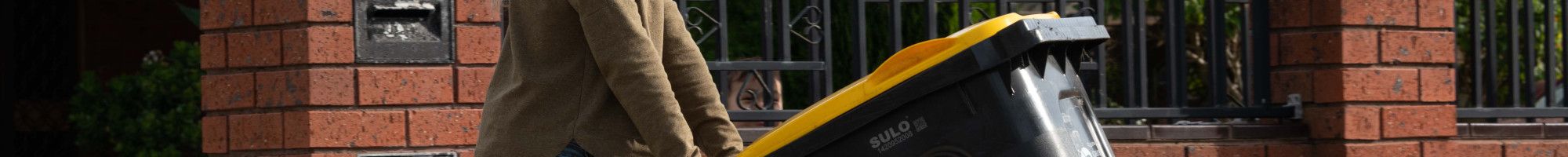 Resident pushing recycle bin out to the curb