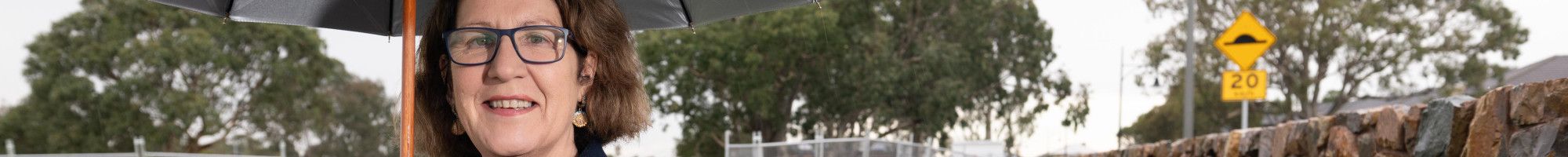Councillor Rhonda Garad standing under an umbrella at the site of the future Keysborough South Hub