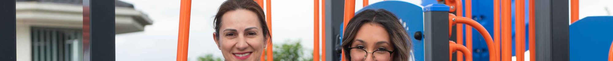 Councillor Lana Formoso with a young resident on play equipment.