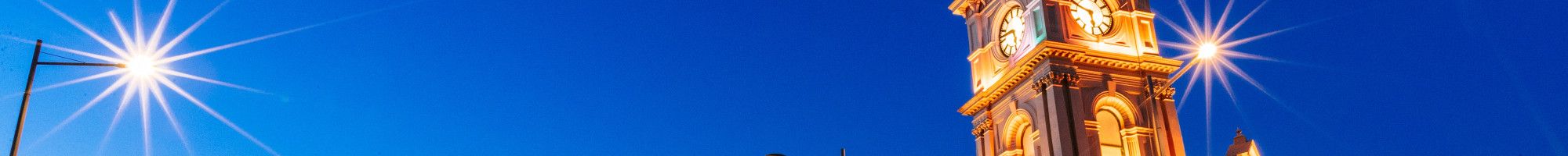 Large historical building lit up at dusk.