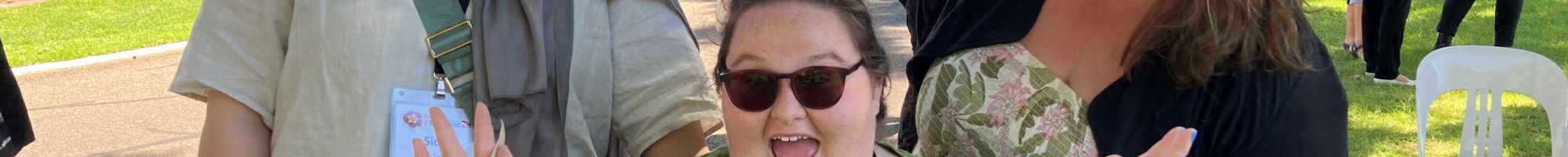 Three people smiling and waving at the camera.