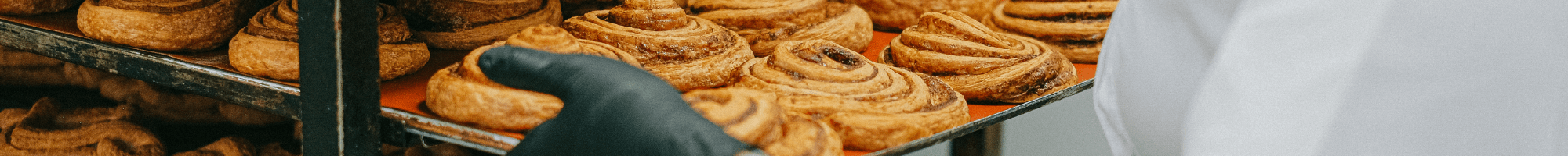 A baker loading pastries on to a rack.