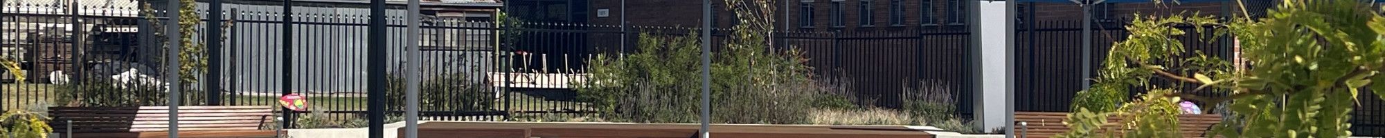 Landscaped area with tables and umbrellas.