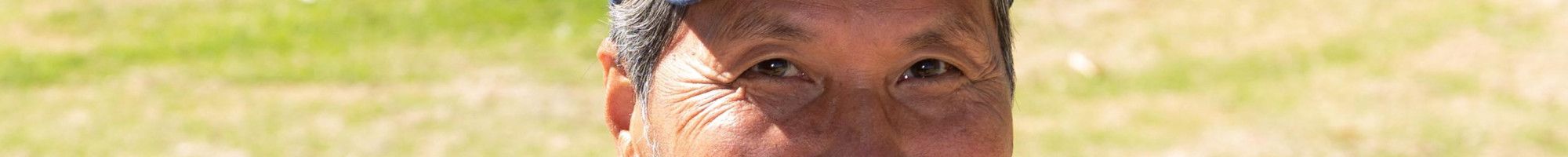 Smiling Vietnamese man wearing a hat featuring the Australian flag.