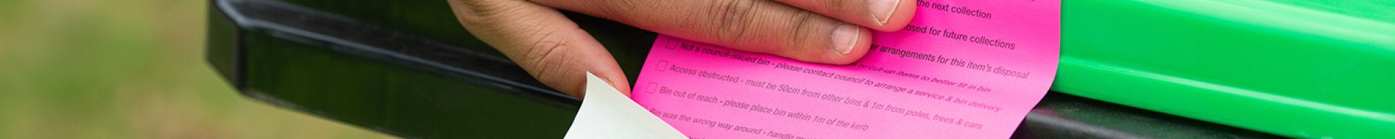 Someone putting a sticker on a bin