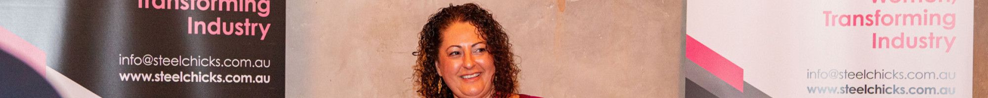 A lady talking holding a microphone and paper